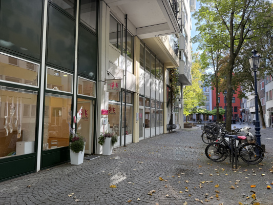 Freundliche Außenansicht der Tanzschule und Ballettschule NAF DANCE Köln im Brigittengässchen mit Fensterfront und Blumen am Eingang